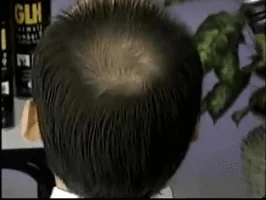 A nineties hair dye advert, filmed close on the back of a head beside a Dark Brown colour swatch.